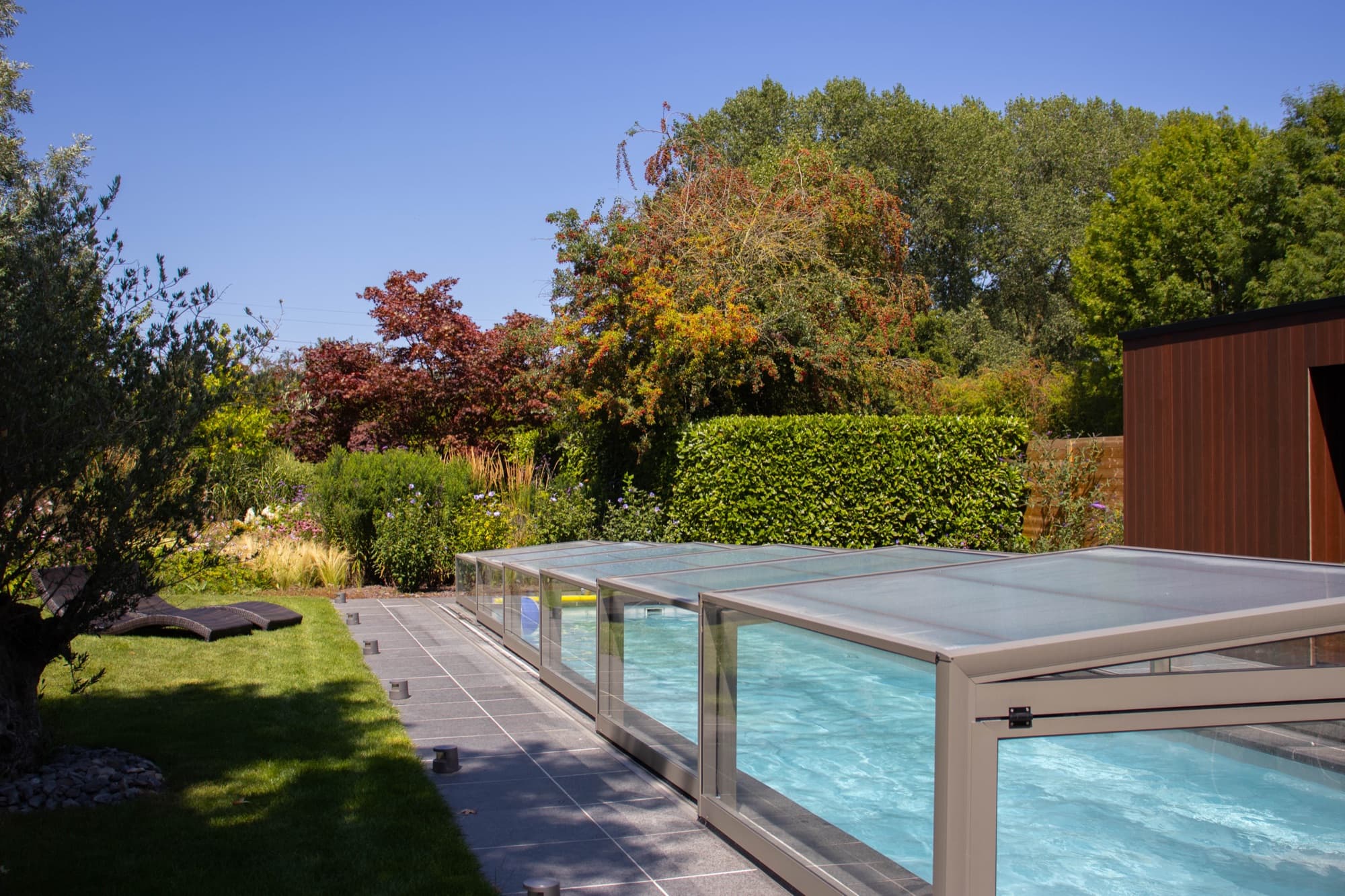 Het zwembad en poolhouse in de groene tuin